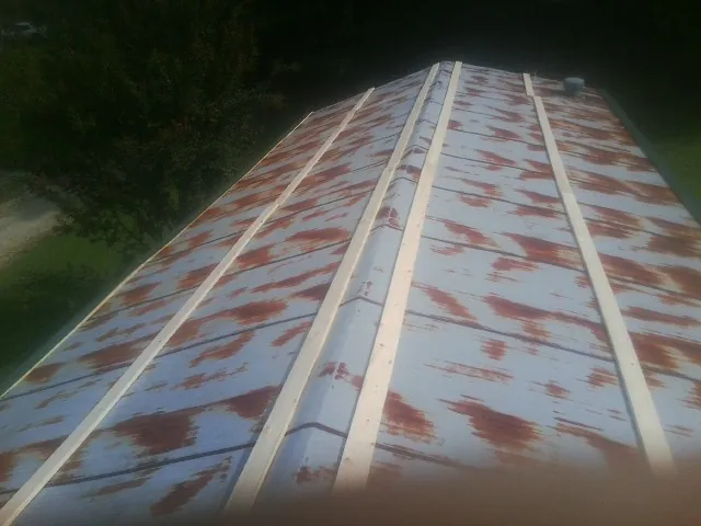 Rusted metal roof panels with new wood purlins before replacement — Storm Damage Roof Repair in Saint Leonard by Roofing Brothers