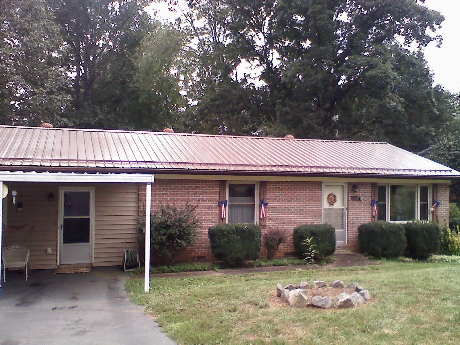 Bronze metal roof and carport on a brick ranch home — Roof Repair work by our crew in Saint Leonard